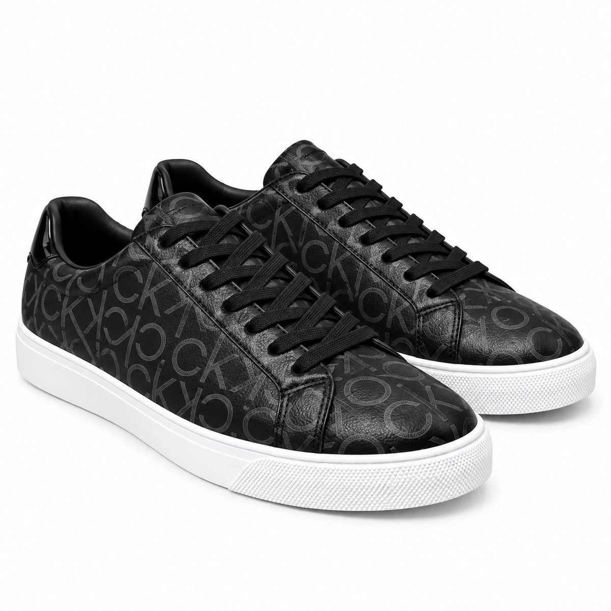 Par de zapatillas Calvin Klein negras con monograma CK sobre fondo blanco