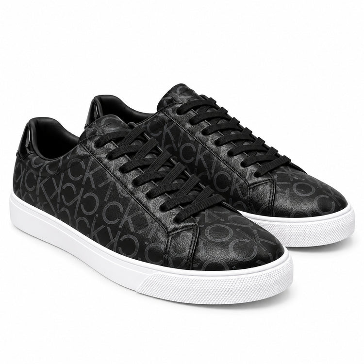 Par de zapatillas Calvin Klein negras con monograma CK sobre fondo blanco