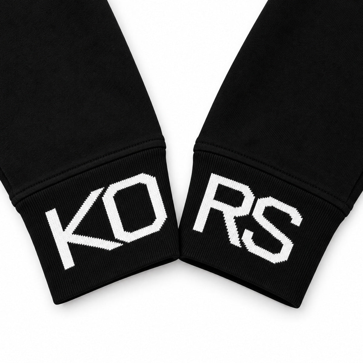 Acercamiento de los puños KO y RS del polerón Michael Kors negro