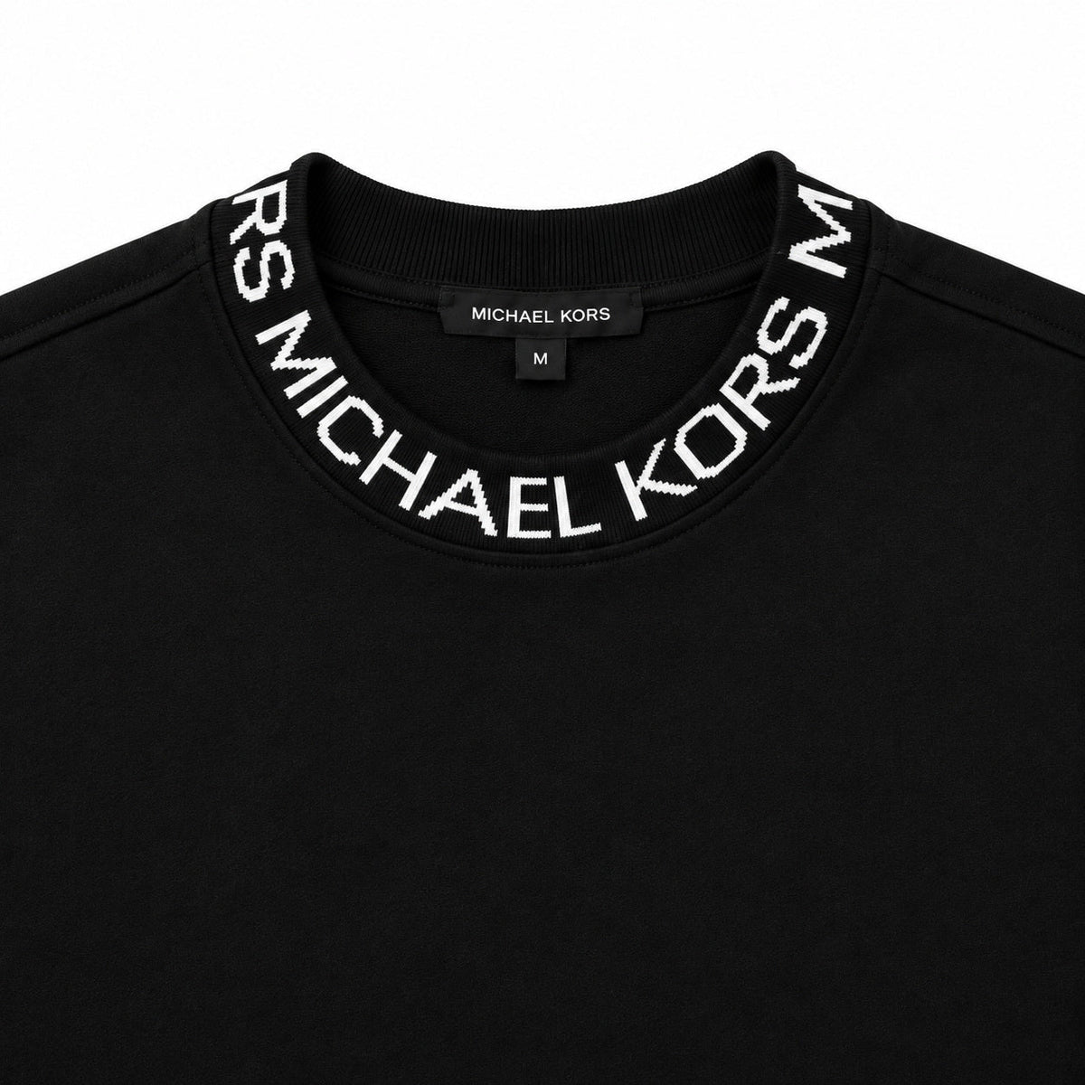 Acercamiento del cuello con letras Michael Kors del polerón negro