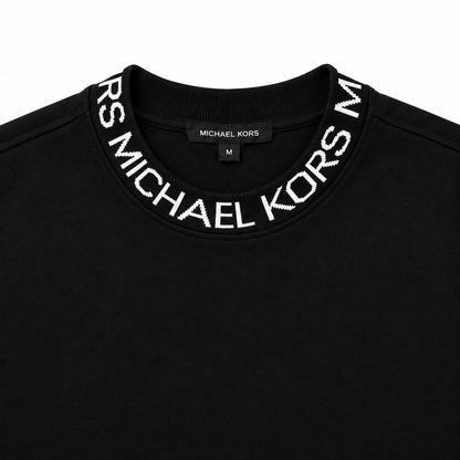 Acercamiento del cuello con letras Michael Kors del polerón negro