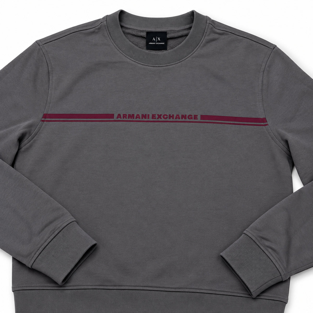 Detalle del logotipo burdeo del polerón Armani Exchange gris